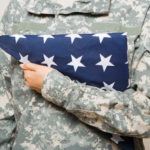 Soldier holding folded American flag